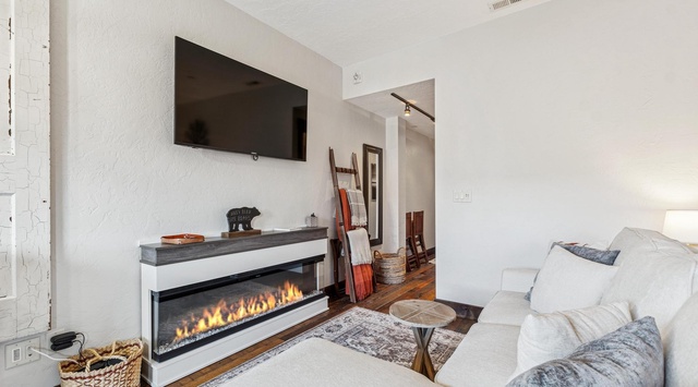 Unwind on plush white sofas while the fireplace creates a cozy ambiance in your stylish living space.