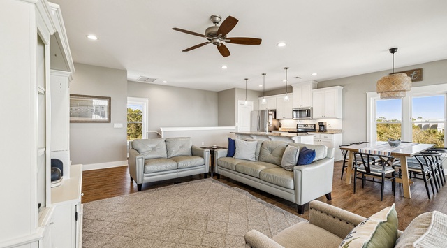 Relax in your spacious open-concept living area with plush seating, modern kitchen, and natural light streaming through large windows.