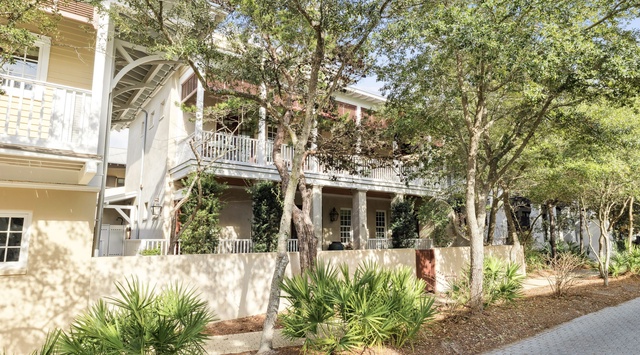 Charming coastal-style homes nestled among mature oak trees create a peaceful neighborhood setting.