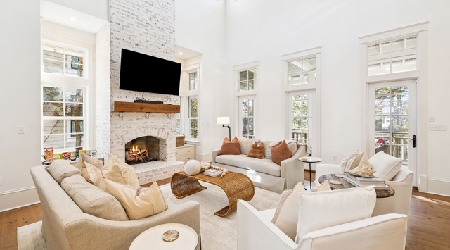 Relax in your elegant living room with soaring ceilings, cozy fireplace, and abundant natural light streaming through tall windows.