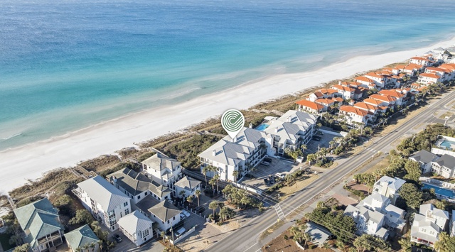 Aerial view of beachfront community featuring white sand beach and turquoise waters along the Gulf Coast.