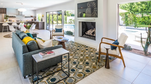 Settle into the stylish living room where modern comfort meets artistic flair. Relax by the fireplace or enjoy the seamless flow to your private pool through expansive glass doors.
