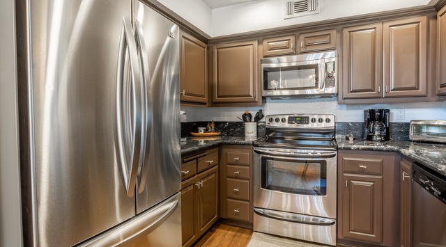 Step into your fully equipped kitchen where stainless steel appliances and granite countertops await. Everything you need to prepare meals is at your fingertips, from the spacious refrigerator to the convenient microwave and coffee maker.