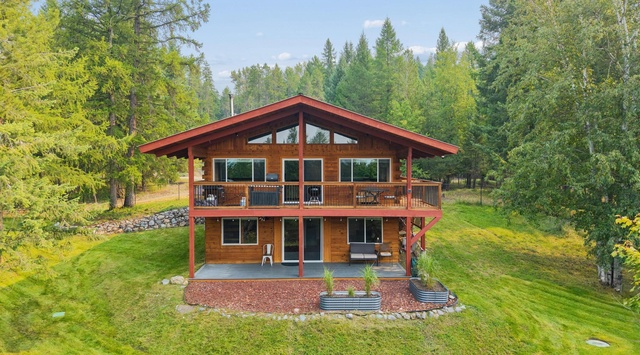A charming cedar cabin nestled in lush forest surroundings, featuring wraparound decking and spacious grounds perfect for outdoor gatherings.