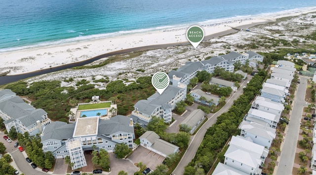 Aerial view of a beachfront vacation community featuring direct access to pristine white sand beaches and turquoise Gulf waters, with nearby swimming pool and coastal walking paths.