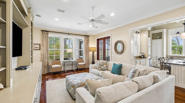 Settle into this inviting living room where plush sofas and warm wood floors create your perfect retreat. Natural light pours through the windows, highlighting the cozy sitting nook and seamless flow to the kitchen.