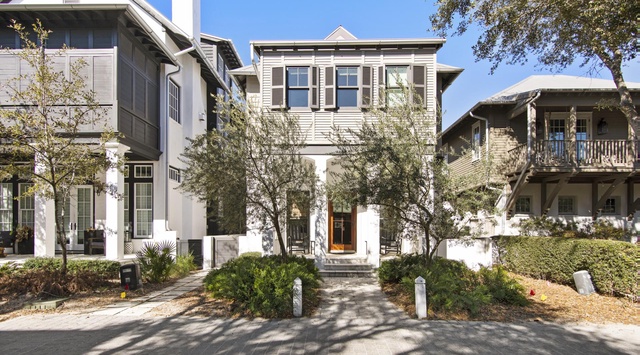 A charming vacation home nestled in a peaceful coastal neighborhood, featuring classic architecture and mature landscaping that frames your private getaway.