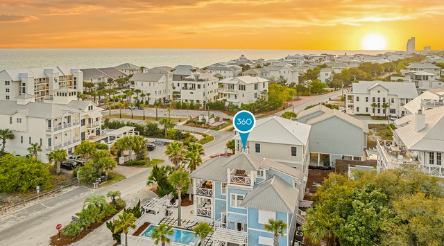 Stunning beachside community at golden hour, featuring modern coastal homes with pool amenities near pristine shoreline.