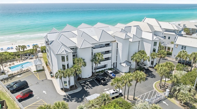 Beachfront resort complex with pristine white sand beach and turquoise waters just steps away from elegant accommodations.