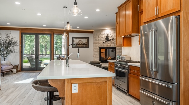 Step into your fully equipped gourmet kitchen, where rich wood cabinetry and gleaming stainless-steel appliances set the stage for effortless meal prep and warm gatherings around the bright island.