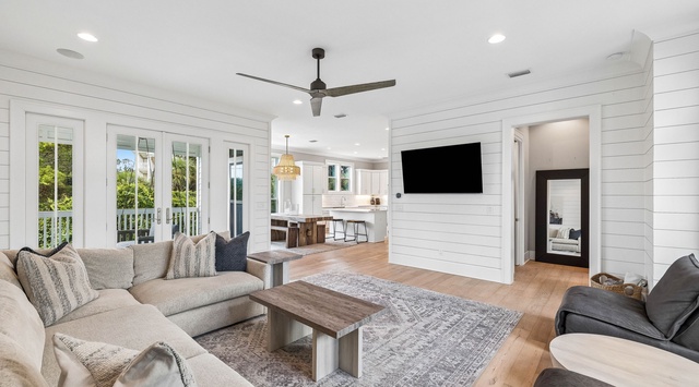 Settle into this bright, breezy living space where coastal charm meets modern comfort. You'll love the shiplap walls, warm wood floors, and open flow to the kitchen—perfect for gathering after a day of adventure.