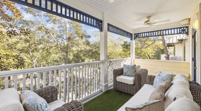 Unwind on your private covered balcony, where comfortable wicker seating and lush tree views create the perfect morning coffee sanctuary.