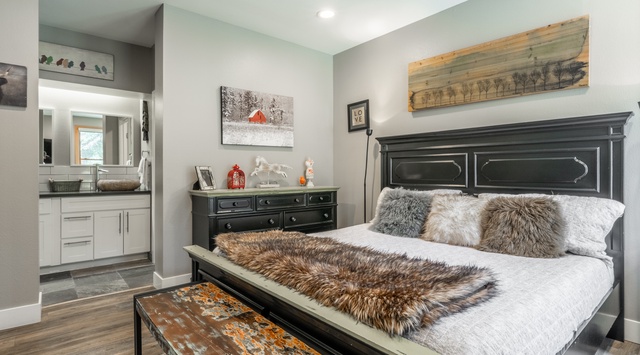 Sink into plush faux fur throws and cozy pillows in your elegantly appointed bedroom, complete with rustic charm and en-suite convenience.