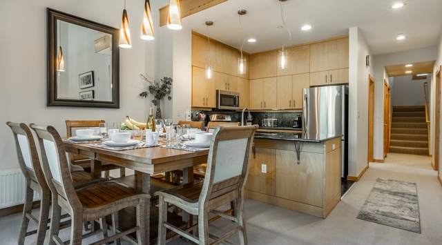 Gather around this inviting dining table where your group can share meals and memories. The open kitchen layout and modern appliances make cooking together a breeze.