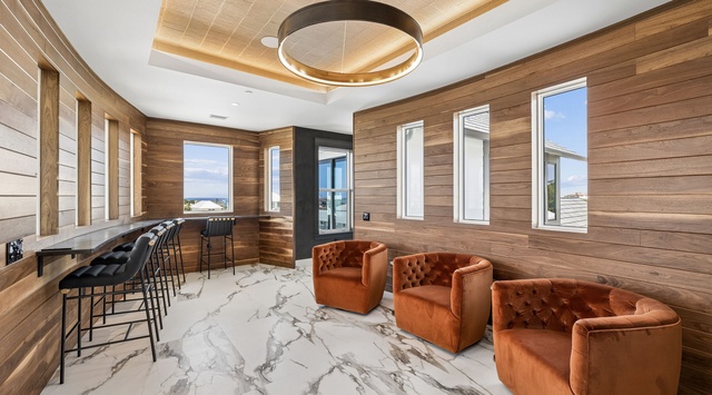 Settle into plush seating surrounded by warm wood tones and natural light, with a stylish bar area perfect for your morning coffee or evening unwind.