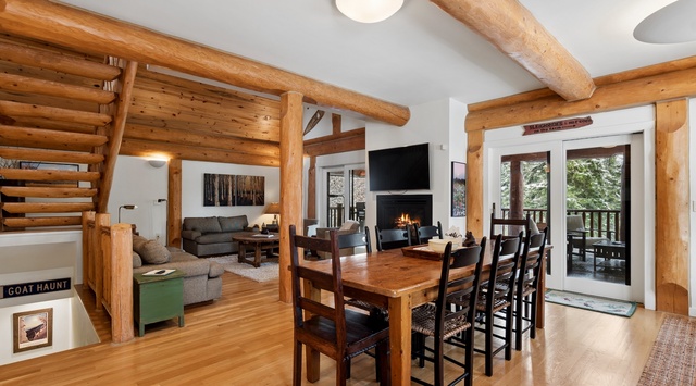 Gather around your rustic dining table while warm wood beams frame cozy evenings by the fireplace.