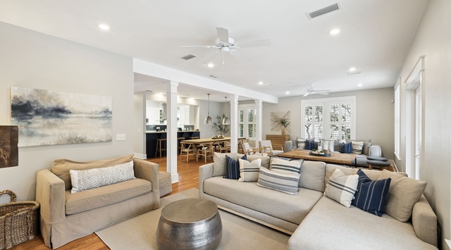 Relax in your spacious open living area with plush sectional seating, where natural light flows through large windows creating a bright, welcoming atmosphere.