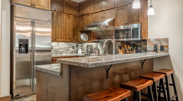 Your fully equipped kitchen blends rich wood cabinetry, granite counters, and stainless appliances. Pull up a stool at the breakfast bar and start planning your mountain escape.