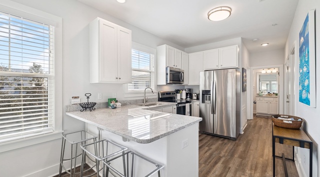 Step into your bright, modern kitchen with granite countertops, stainless steel appliances, and a breakfast bar perfect for morning coffee.