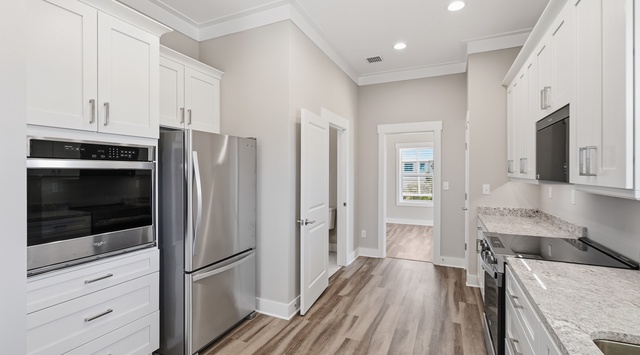 Your fully equipped kitchen features granite counters, stainless steel appliances, and elegant white cabinetry for effortless meal prep.
