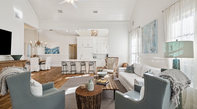 Relax in this elegant open-concept living space where coastal blues meet warm whites, creating your perfect sanctuary for unwinding after beach adventures.