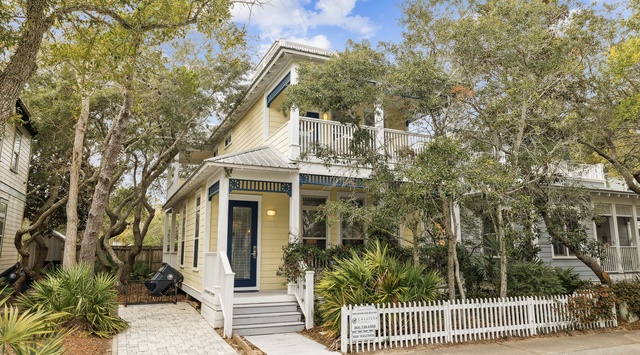 Charming coastal cottage with inviting front porch and lush tropical landscaping creates the perfect seaside retreat arrival experience.