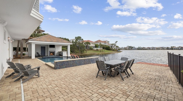 Luxury waterfront property featuring swimming pool, outdoor dining space, and direct lake access with panoramic water views.