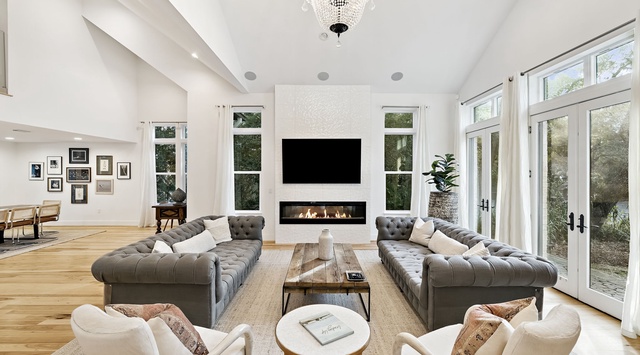 Unwind in your elegant living space with plush seating, a cozy fireplace, and crystal chandelier creating the perfect atmosphere for relaxation.