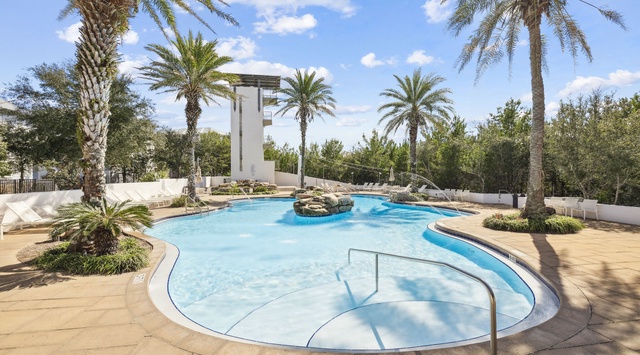 Resort-style pool area with tropical palms and modern architecture creating a serene outdoor oasis.