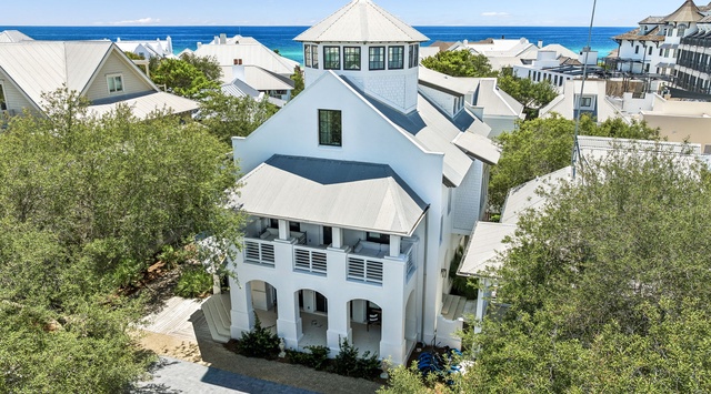 A stunning coastal property with distinctive architecture sits just moments from the turquoise Gulf waters, surrounded by lush greenery and neighboring the charming beach community.