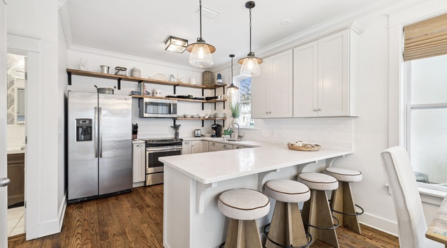 Your bright, modern kitchen features sleek white cabinets, quartz countertops, and a cozy breakfast bar where you can sip coffee while planning your day.