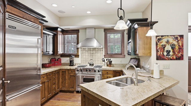 Step into your fully-equipped gourmet kitchen with high-end appliances, granite countertops, and warm wood cabinetry—perfect for whipping up your favorite meals during your mountain getaway.