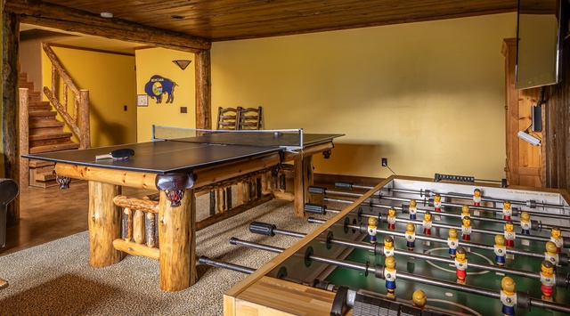 Your private game room awaits with rustic log-crafted ping pong and foosball tables, perfect for friendly competition and making memories together.