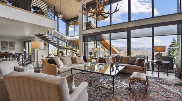 Sink into plush sofas surrounded by soaring windows that frame breathtaking mountain views, creating your perfect retreat.