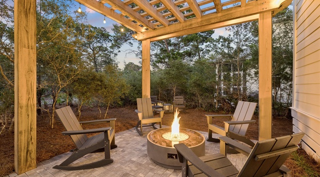 Picture yourself unwinding under the stars in this inviting outdoor space, where a warm fire pit glows beneath a handsome wood pergola. Sink into cozy chairs and feel the gentle evening breeze.