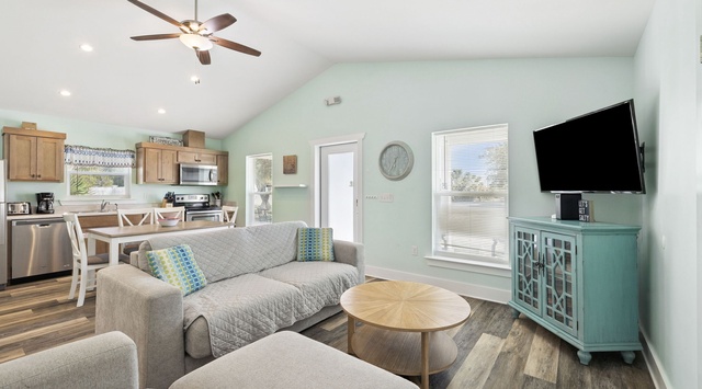 Relax in your bright, open-concept living space with cozy seating, modern kitchen, and soothing coastal colors.