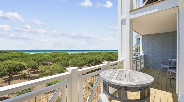 Sip your morning coffee at this cozy balcony table while the turquoise sea stretches endlessly before you, framed by lush greenery and soft coastal breezes.