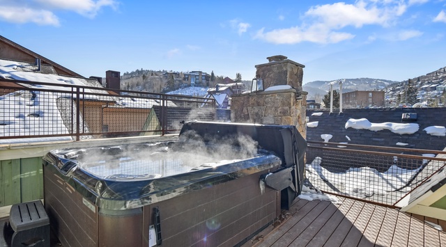 Soak in your private hot tub while winter snow blankets the mountain town around you, creating the perfect alpine getaway.