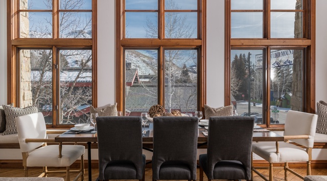 Your elegant dining space showcases mountain views through floor-to-ceiling windows, creating the perfect backdrop for memorable meals together.