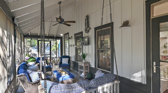Unwind on your covered porch with cozy swing and plush seating, where ceiling fans keep you cool as natural light dances through.