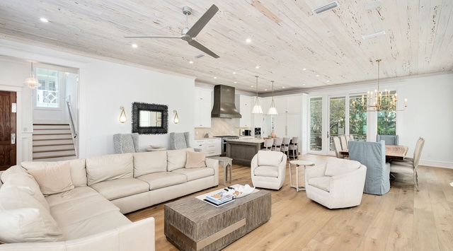 Bright, spacious living area with vaulted ceilings, plush seating, and seamless flow to a chef's kitchen—perfect for gathering and making memories together.