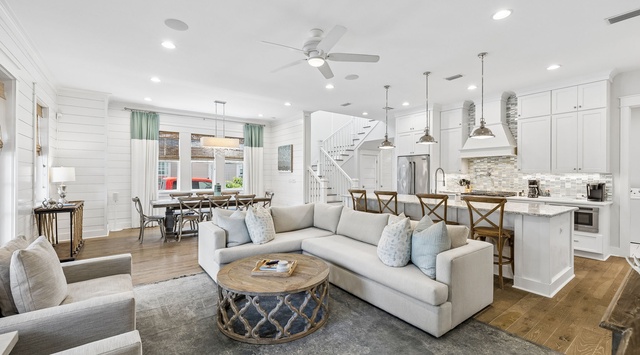 Settle into this bright, open living space where coastal charm meets modern comfort. Soft sofas and a welcoming kitchen island create a relaxed atmosphere for your memorable stay.