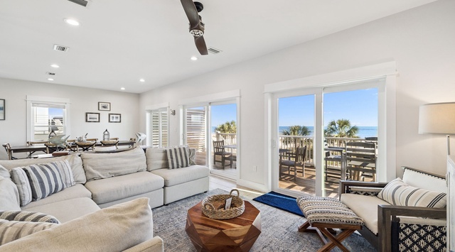 Sink into plush comfort while ocean breezes flow through your bright living space, where every window frames stunning coastal views and swaying palms.