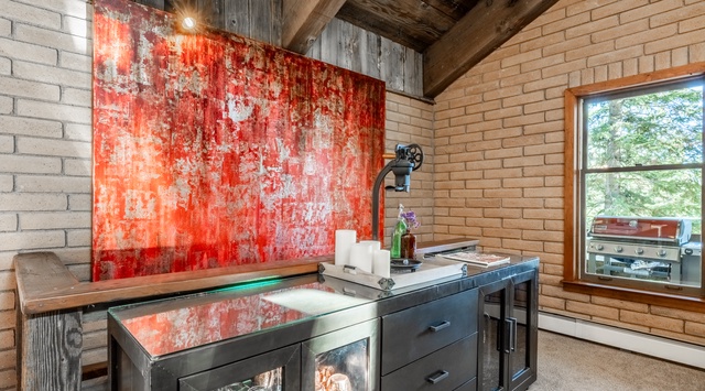 Step into your own industrial-chic creative space, where rustic charm meets modern convenience. Vaulted wood-beam ceilings soar above, while the bold red statement wall adds character and warmth to inspire your next adventure.