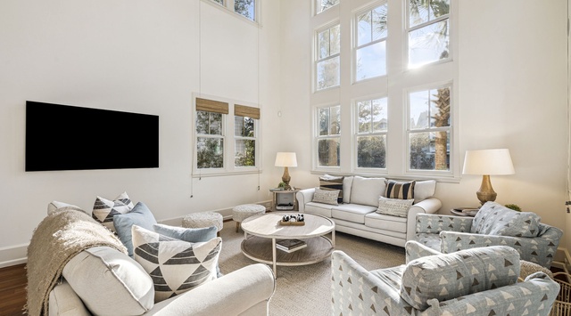Sink into plush seating surrounded by soaring windows that flood your space with natural light and garden views.