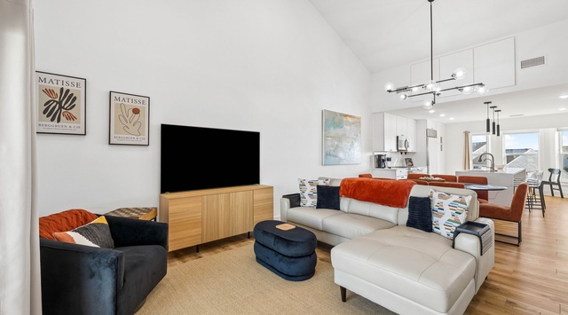 Inviting open-concept living space flooded with natural light, featuring plush seating and a dining area—the perfect retreat after exploring or enjoying meals together.