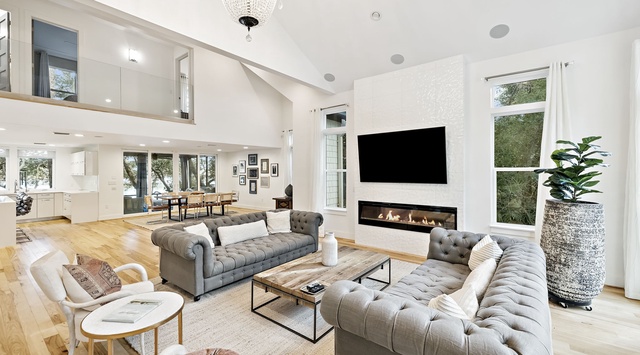 Unwind in your stunning great room with soaring ceilings, elegant chandelier, cozy fireplace, and plush seating perfect for memorable gatherings.