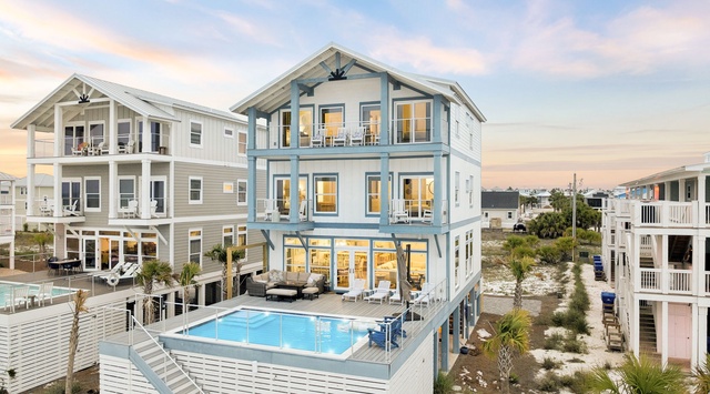 Modern coastal architecture features multiple balconies and a rooftop pool, set in a quiet beachside neighborhood at golden hour.