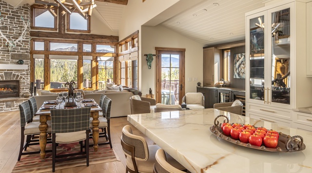 Relax in this bright, open living space where rustic wood beams meet modern elegance. Natural light pours through tall windows, and the cozy fireplace invites you to unwind after a day of mountain adventures.