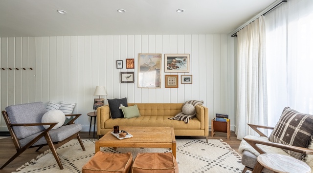 Relax in this stylish living room with vintage-modern charm, plush seating, and warm natural light streaming through soft curtains.